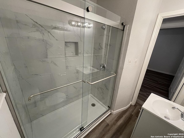 2025 Texas, San Antonio, TX 78228 - full bathroom featuring wood finished floors, a stall shower, vanity, and a textured wall