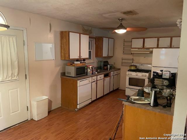 12315 Royal Grn, Conroe, TX 77303 - kitchen featuring white appliances, under cabinet range hood, a ceiling fan, light wood-type flooring, and white cabinets