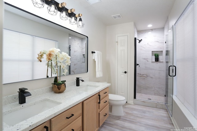 16063 Walnut Crk, San Antonio, TX 78247 - bathroom with a shower stall, double vanity, wood finished floors, and recessed lighting