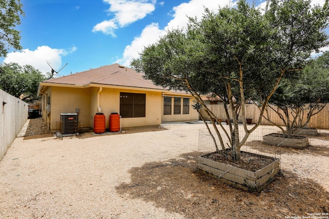 16063 Walnut Crk, San Antonio, TX 78247 - rear view of property featuring stucco siding, a fenced backyard, and a vegetable garden