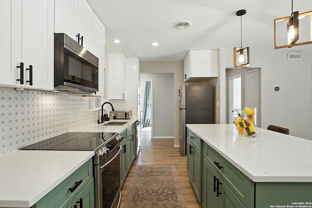 619 Olney Dr, San Antonio, TX 78209 - kitchen featuring green cabinets, stainless steel appliances, light wood-type flooring, white cabinets, and recessed lighting