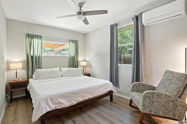619 Olney Dr, San Antonio, TX 78209 - bedroom featuring a wall mounted air conditioner, multiple windows, wood finished floors, and ceiling fan