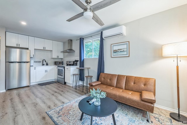 619 Olney Dr, San Antonio, TX 78209 - living area featuring a wall mounted air conditioner, a ceiling fan, and light wood finished floors