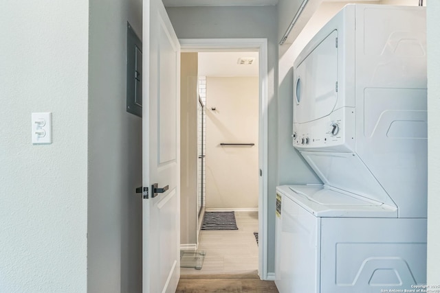 619 Olney Dr, San Antonio, TX 78209 - washroom featuring stacked washing machine and dryer and wood finished floors