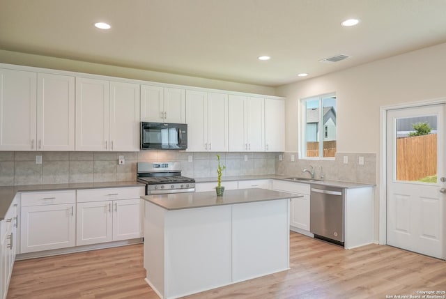 27422 Bighorn Sheep, Boerne, TX 78015 - kitchen with stainless steel appliances, white cabinetry, light wood finished floors, recessed lighting, and decorative backsplash