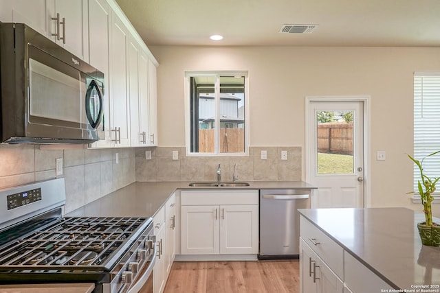 27422 Bighorn Sheep, Boerne, TX 78015 - kitchen featuring stainless steel appliances, light wood finished floors, white cabinetry, decorative backsplash, and recessed lighting