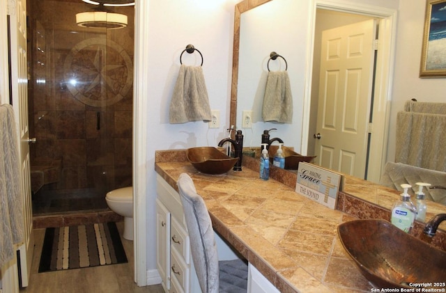 105 Yucca, Jourdanton, TX 78026 - full bathroom with a shower stall, double vanity, and wood finished floors