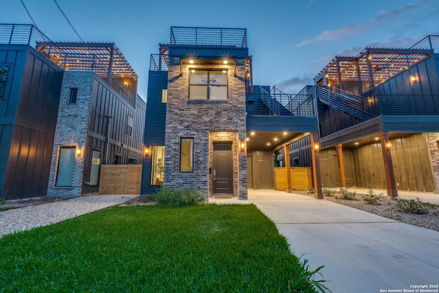 111 Dowdy, San Antonio, TX 78204 - modern home featuring concrete driveway, brick siding, a carport, and a balcony