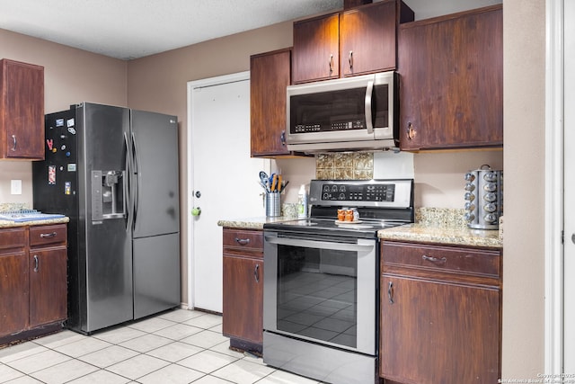 9830 Lauren Mist, San Antonio, TX 78251 - kitchen featuring appliances with stainless steel finishes, light tile patterned flooring, and light stone counters