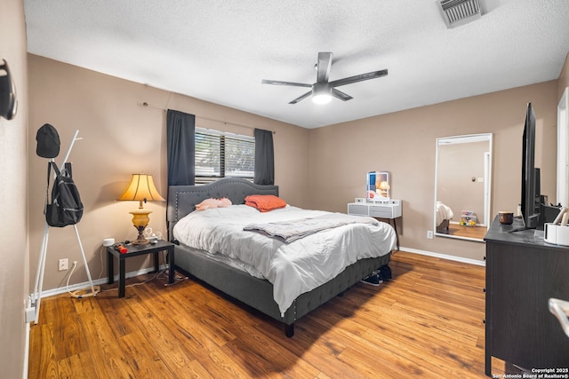 9830 Lauren Mist, San Antonio, TX 78251 - bedroom with a textured ceiling, wood finished floors, and ceiling fan