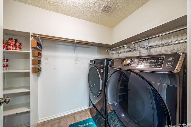 8810 Sebec Cir, San Antonio, TX 78250 - laundry room featuring washing machine and clothes dryer, a textured ceiling, and tile patterned flooring
