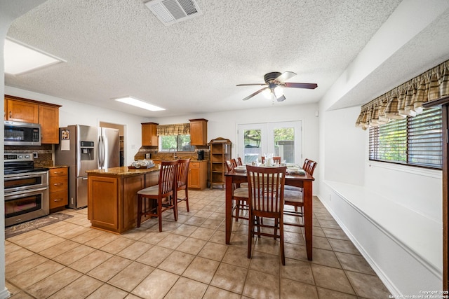 8810 Sebec Cir, San Antonio, TX 78250 - dining space with a ceiling fan, a textured ceiling, and light tile patterned floors