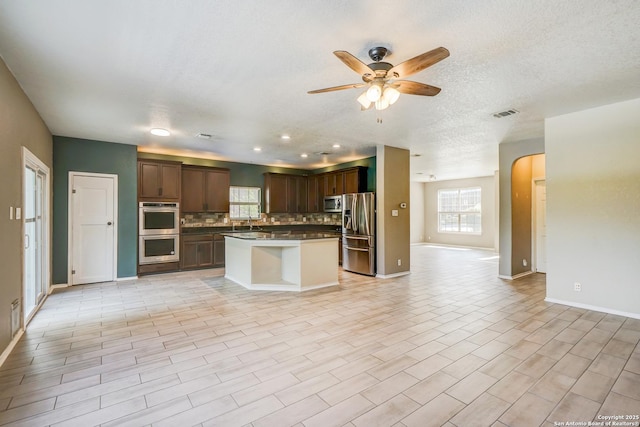 4763 Bending Grv, San Antonio, TX 78259 - kitchen with appliances with stainless steel finishes, open floor plan, ceiling fan, tasteful backsplash, and arched walkways