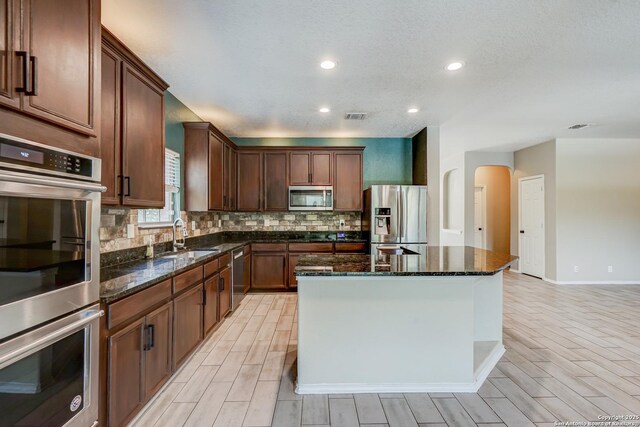 4763 Bending Grv, San Antonio, TX 78259 - kitchen featuring stainless steel appliances, arched walkways, backsplash, wood finish floors, and recessed lighting