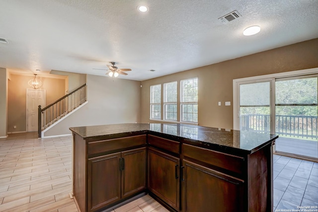 4763 Bending Grv, San Antonio, TX 78259 - kitchen featuring ceiling fan, dark stone counters, a textured ceiling, and light tile patterned flooring