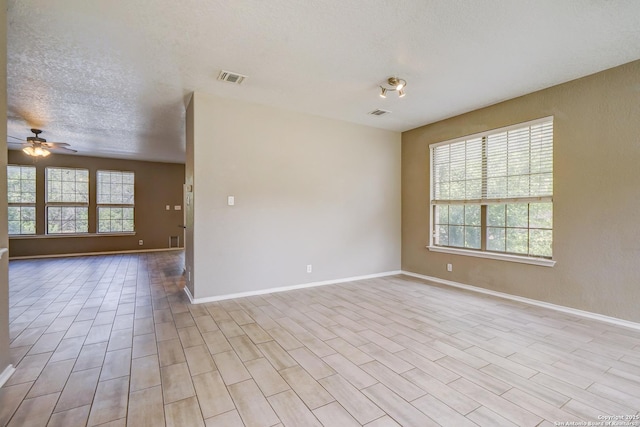 4763 Bending Grv, San Antonio, TX 78259 - empty room featuring plenty of natural light, ceiling fan, a textured ceiling, and light wood-style flooring