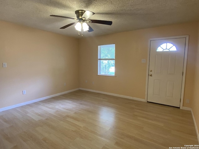 305 Osage, Refugio, TX 78377 - entryway with light wood finished floors, healthy amount of natural light, ceiling fan, and a textured ceiling