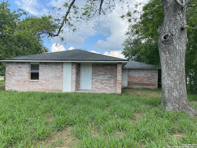 305 Osage, Refugio, TX 78377 - back of property with roof with shingles and brick siding