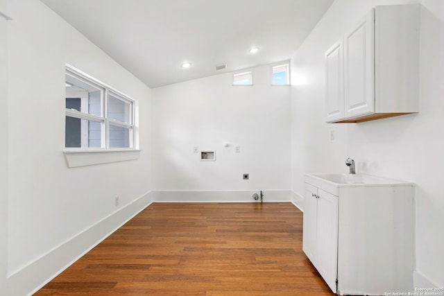 110 Vitra, San Antonio, TX 78210 - laundry room featuring hookup for an electric dryer, washer hookup, wood finished floors, recessed lighting, and cabinet space