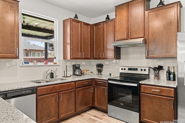 6583 Runaway, Converse, TX 78109 - kitchen with appliances with stainless steel finishes, under cabinet range hood, decorative backsplash, and light wood-style flooring