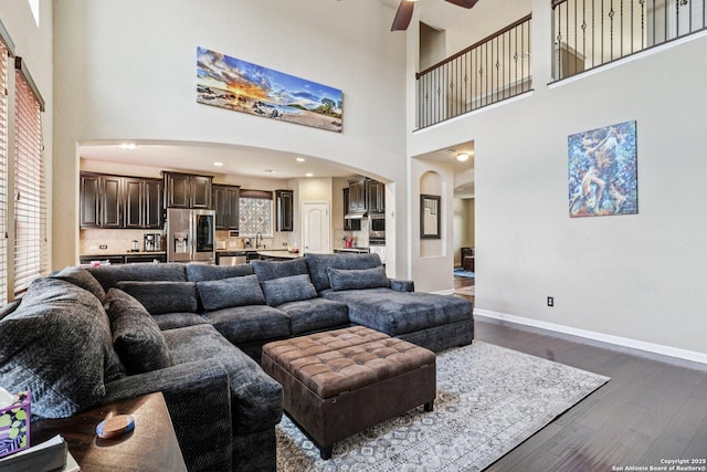 630 Oxalis, San Antonio, TX 78260 - living room with arched walkways, a high ceiling, dark wood-style floors, and a ceiling fan