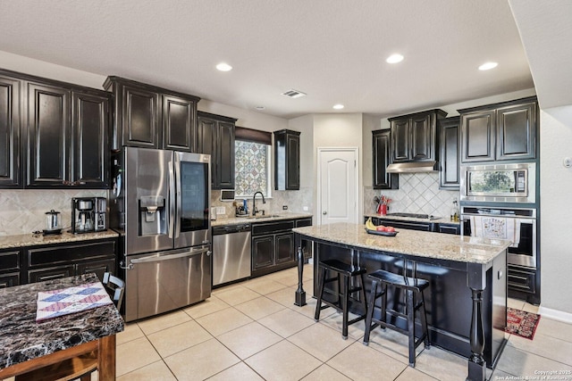 630 Oxalis, San Antonio, TX 78260 - kitchen featuring stainless steel appliances, dark cabinetry, tasteful backsplash, and recessed lighting