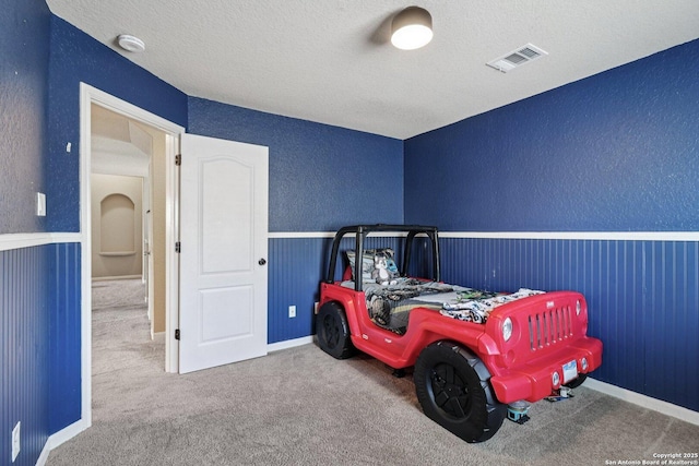 630 Oxalis, San Antonio, TX 78260 - carpeted bedroom with wainscoting, a textured wall, and a textured ceiling