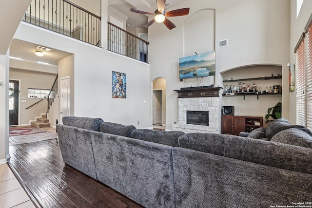 630 Oxalis, San Antonio, TX 78260 - living area with a ceiling fan, a fireplace, a high ceiling, hardwood / wood-style floors, and stairs