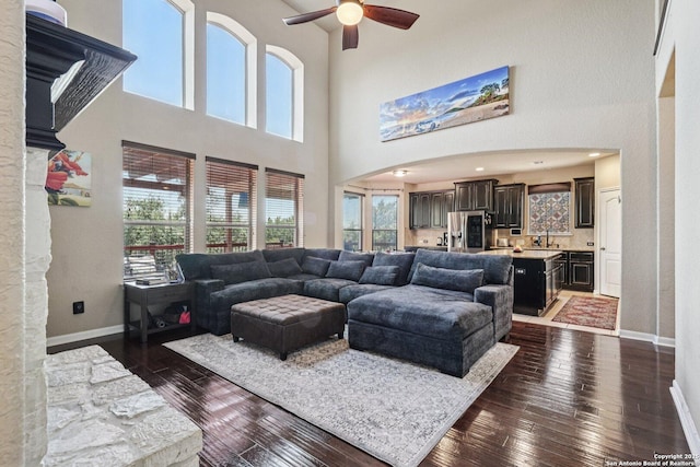 630 Oxalis, San Antonio, TX 78260 - living room featuring ceiling fan, dark wood finished floors, arched walkways, and a towering ceiling