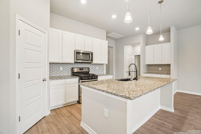 1533 Cawdon Park, Bulverde, TX 78163 - kitchen with stainless steel appliances, light wood-style floors, tasteful backsplash, a kitchen island with sink, and recessed lighting