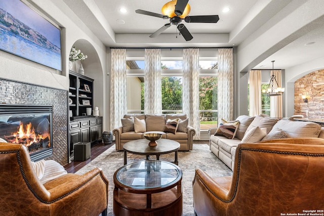 22715 Colibries, San Antonio, TX 78261 - living room with a fireplace, wood finished floors, ceiling fan, a chandelier, and arched walkways