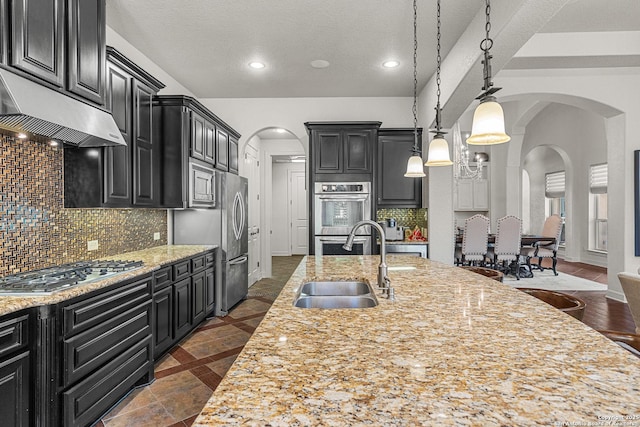 22715 Colibries, San Antonio, TX 78261 - kitchen with appliances with stainless steel finishes, ventilation hood, arched walkways, dark cabinets, and recessed lighting