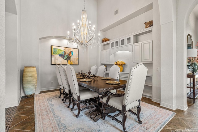 22715 Colibries, San Antonio, TX 78261 - dining area with arched walkways, a towering ceiling, a chandelier, and dark tile patterned floors