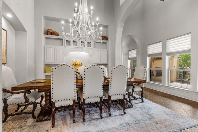 22715 Colibries, San Antonio, TX 78261 - tiled dining space featuring a chandelier, arched walkways, a towering ceiling, and built in features