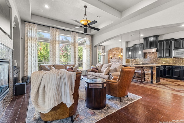 22715 Colibries, San Antonio, TX 78261 - living room featuring a tile fireplace, arched walkways, wood finished floors, recessed lighting, and a ceiling fan