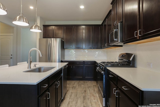 14946 Costa Leon, San Antonio, TX 78245 - kitchen featuring appliances with stainless steel finishes, light countertops, tasteful backsplash, a center island with sink, and light wood finished floors