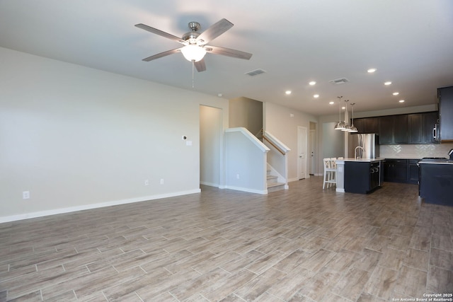 14946 Costa Leon, San Antonio, TX 78245 - unfurnished living room with recessed lighting, stairs, ceiling fan, and light wood finished floors