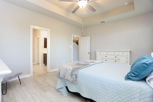 14946 Costa Leon, San Antonio, TX 78245 - bedroom featuring light wood finished floors, a raised ceiling, a ceiling fan, and ensuite bathroom