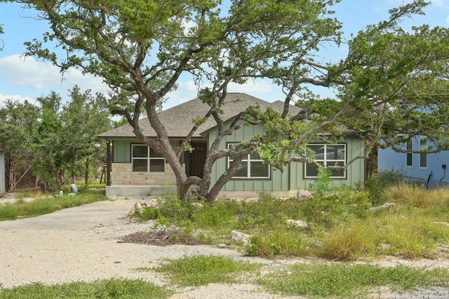 150 Hill Dr, Spring Branch, TX 78070 - view of front of property with board and batten siding, a shingled roof, dirt driveway, and stone siding