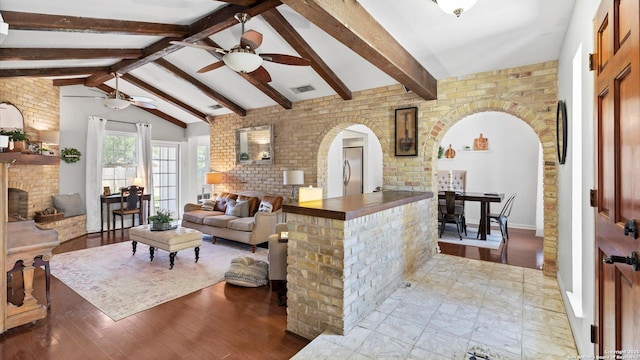 1703 Redwood, Seguin, TX 78155 - living room with arched walkways, ceiling fan, a fireplace, and wood finished floors