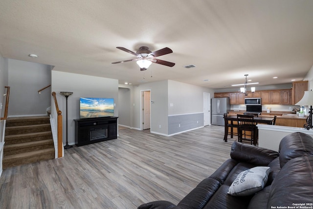 9915 Mustang Isle, San Antonio, TX 78254 - living area with stairs, ceiling fan, light wood-style floors, recessed lighting, and a glass covered fireplace
