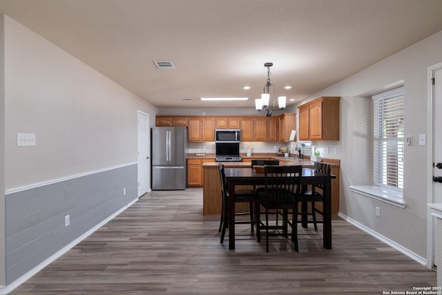 9915 Mustang Isle, San Antonio, TX 78254 - kitchen with appliances with stainless steel finishes, a chandelier, dark wood finished floors, a peninsula, and recessed lighting