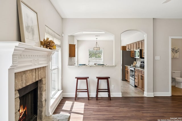 18310 Redwood Path, San Antonio, TX 78259 - living area with wood finished floors, a tiled fireplace, and arched walkways