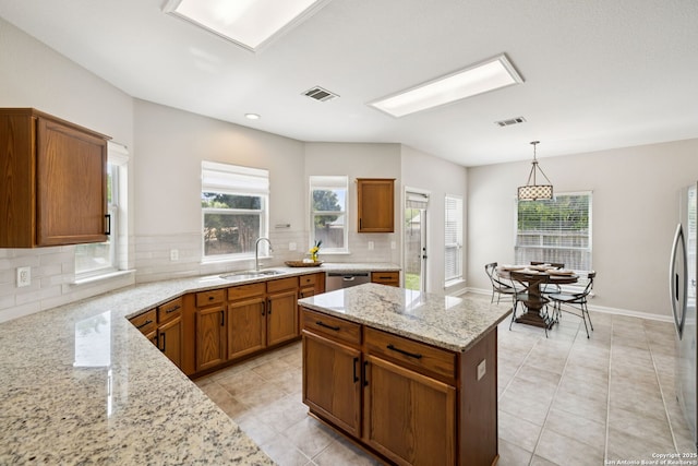 18310 Redwood Path, San Antonio, TX 78259 - kitchen with decorative backsplash, plenty of natural light, light tile patterned floors, brown cabinetry, and recessed lighting
