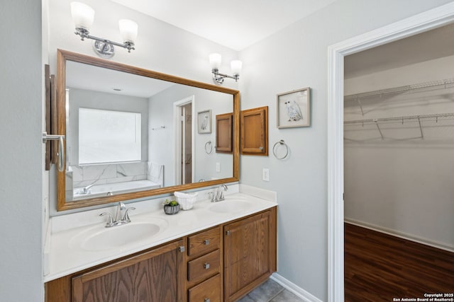18310 Redwood Path, San Antonio, TX 78259 - bathroom featuring double vanity, a garden tub, and a walk in closet