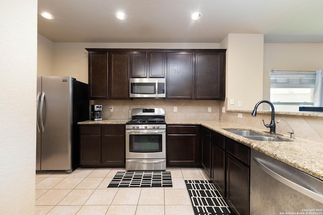 451 Tequila Rnch, San Antonio, TX 78245 - kitchen with stainless steel appliances, backsplash, dark brown cabinetry, light stone counters, and recessed lighting