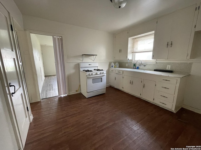 231 Carroll, San Antonio, TX 78225 - kitchen featuring white gas range oven, dark wood-type flooring, light countertops, white cabinets, and tasteful backsplash