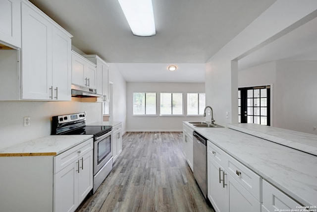 9818 Balanced Rock, Converse, TX 78109 - kitchen featuring stainless steel appliances, under cabinet range hood, light wood finished floors, white cabinets, and light stone countertops
