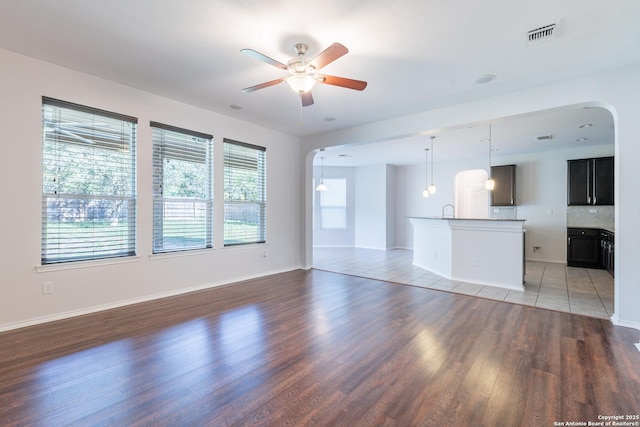 20131 Silver, San Antonio, TX 78259 - unfurnished living room with arched walkways, light wood-style flooring, and a ceiling fan