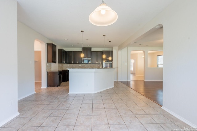 20131 Silver, San Antonio, TX 78259 - kitchen featuring appliances with stainless steel finishes, arched walkways, tasteful backsplash, light tile patterned flooring, and open floor plan